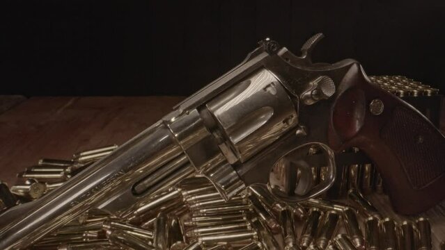 Dolly in of beautiful .357 magnum revolver surrounded by shining cartridges