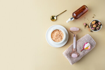 Spa concept composition. Towel with frangipani r, gua sha massage roller, essential oil , aromatic...