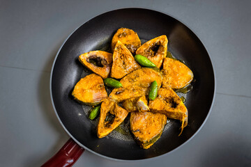 Raw uncooked marianted piece of Ilish fish or Hilsha fish. close up. macro. dark background.
