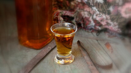 Whisky. Glass of whiskey on wood background. Bottle of whiskey on old wooden chest.