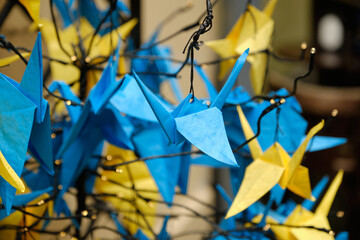Japanese origami birds of peace blue and yellow concept of peace and help in the war. Concept of the Independence Day of Ukraine.