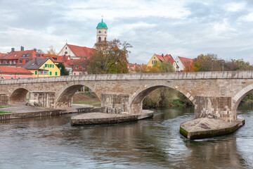 Obraz premium Bridge over Danube in Regensburg Germany . Medieval Arch bridge over the river . Steinerne Brucke