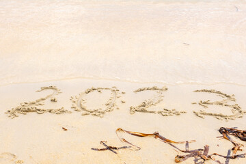2023 happy New Year coming concept, numbers 2023 on the sand near the sea