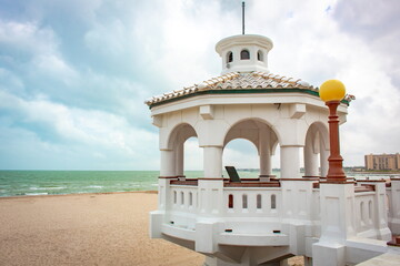 White pavilion at the beach and bay in Corpus Christi Texas on a blue cloudy day