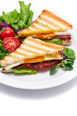 French toasts with fried eggs, cream cheese, salad and bacon