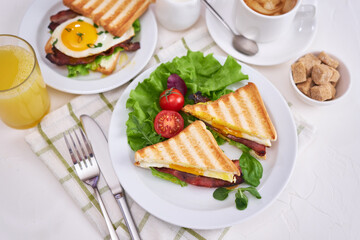 Tasty breakfast - sandwiches with fried eggs and bacon and fresh hot coffee