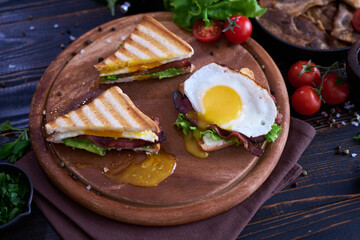 French toasts with fried eggs, cream cheese, salad and bacon