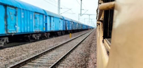 Blurr view of freight train standing next to the passenger train