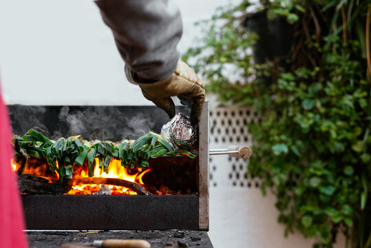 Unrecognizable person grilling calcots on terrace