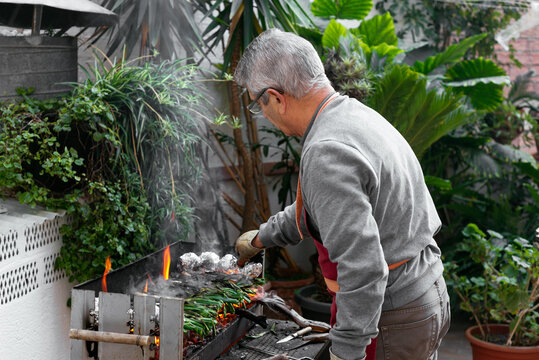 Man grilling calcots on terrace