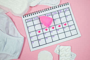 calendar photo, underwear, menstrual cup, sanitary napkins on isolated pastel pink background.