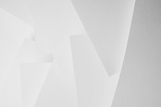 White abstract geometric background with soft light paper sheets fly as spaces in chaotic pattern with glow and gradient in simple monochrome modern style for business.