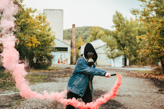 Person holding smoke bomb on street