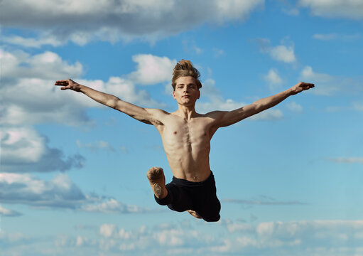 Young slim elegant performer doing twine in air