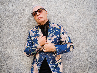 Handsome elderly man in trendy colorful suit on street