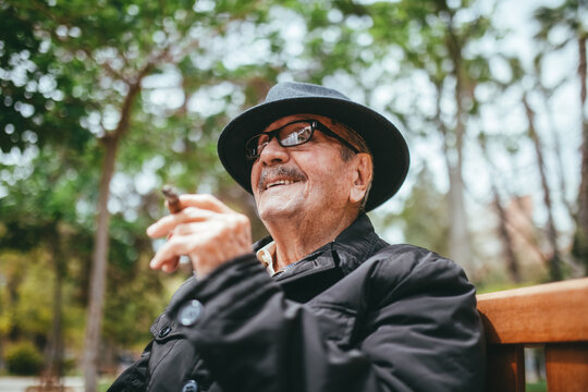 Elderly man smoking cigar on street