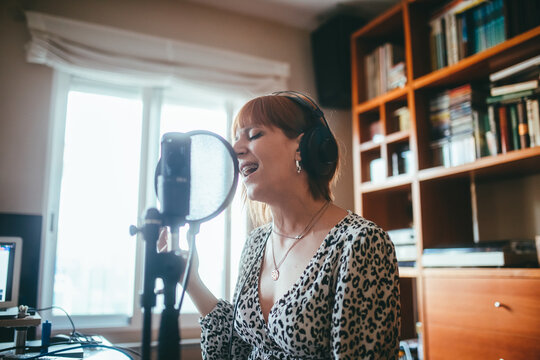 Singer performing song into microphone at home