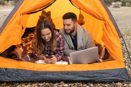 Camping Couple Inside Tent Using Gadgets