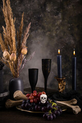 Halloween still life with skull, bones and cake