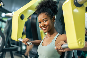 African sportswoman slow lift up weight machine or barbell in stadium.