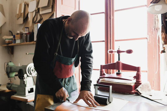 Man cutting textile in atelier
