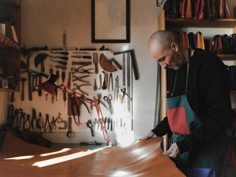 Man cutting textile in atelier