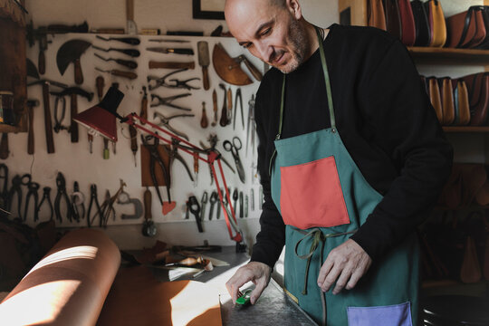 Man cutting textile in atelier