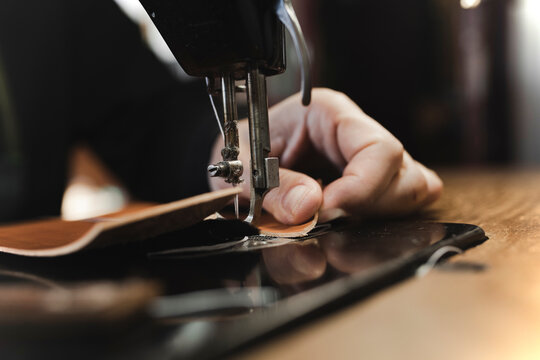 Man stitching textile in atelier