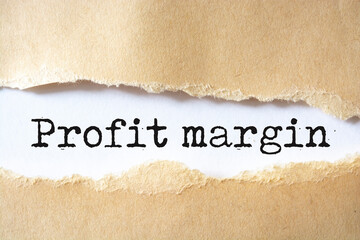 Profit Margin text on torn cardboard. Black letters on white paper