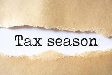 The text tax season behind torn brown paper