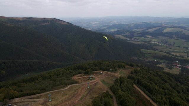 following after paraglider flying above ukrainian carpathian mountains