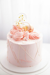 
Pink birthday cake decorated with candies and meringue for a girl for a birthday or Valentine's day on a white background