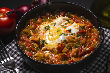 Tasty pisto with egg and vegetables in bowl