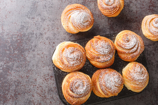 Modern fashionable pastries scones cruffins puffmaffin a mixture of a croissant and maffin closeup in the muffin pan on the table. Horizontal top view from above