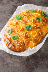 St Johns cake coca de sant joan with pine nuts, candied fruit closeup on the paper on the table....
