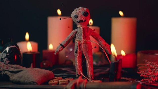 Voodoo doll in ritual scene close up, magic table with candles, witchcraft and spirituality concept.