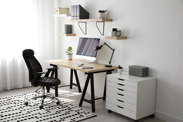 Comfortable office chair near table with modern computer