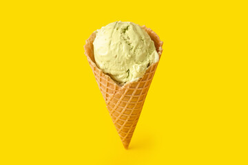 Delicious ice cream in waffle cone on yellow background