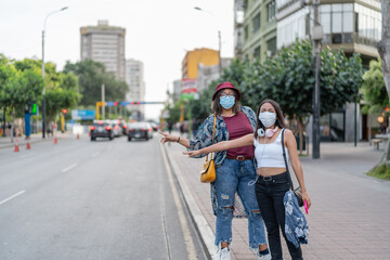 Peruvian women in medical masks hailing taxi