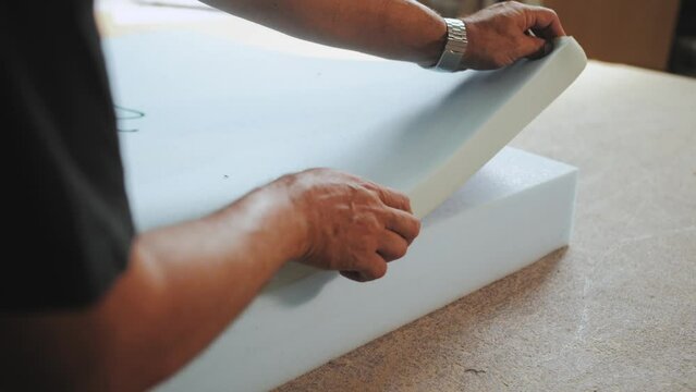 The factory for the manufacture of upholstered furniture. Gluing of foam rubber. The process of assembling and gluing upholstered furniture. Close-up. Unrecognizable 