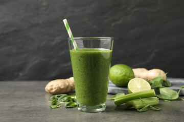 Green juice and fresh ingredients on grey table