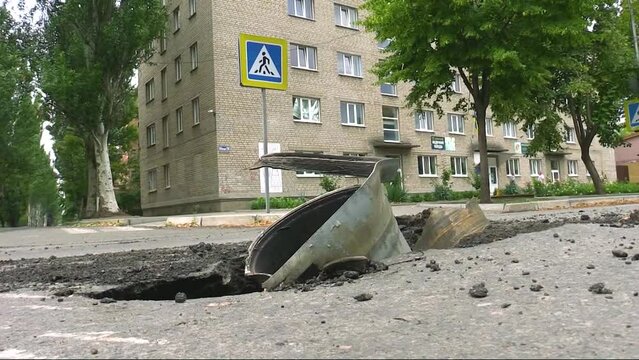 A metal shell is visible from the asphalt near a house in the city. The Russian army is shelling Ukrainian cities. Real War 2022, Russia Attacked Ukraine