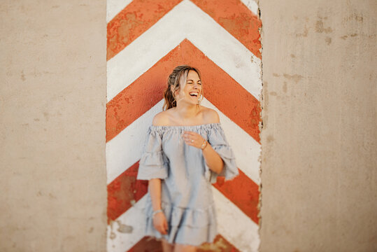 Happy woman laughing against shabby wall