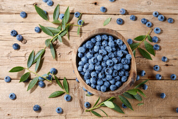 Fresh blueberries in bowl on wooden planks