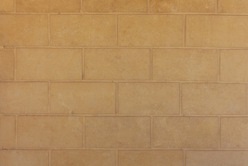 Decorative large brick wall close up in beige brown colors. Abstract texture. Horizontal brick tile background.