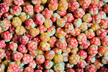 Full frame texture of cloudberries are scattered on table to dry.