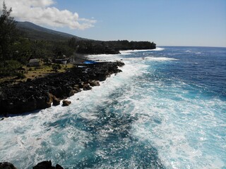 Aerial view of a coastline with cliff and foam in the water from a drone