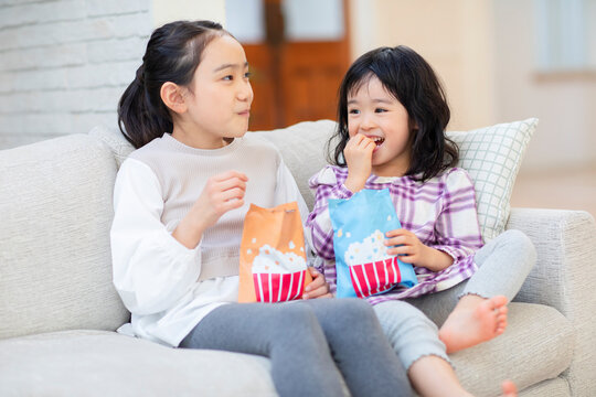 お菓子を食べる姉妹
