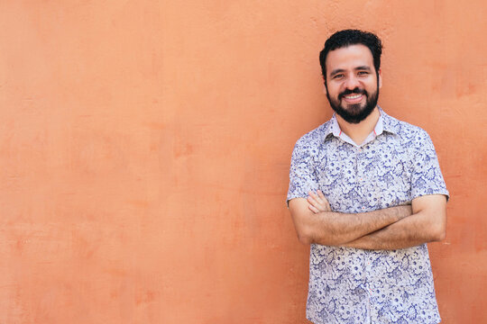 Happy ethnic man leaning on the wall
