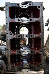 A four-cylinder engine dissembled and removed from car on a workbench in a vehicle repair workshop....